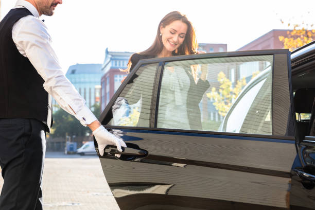 Chauffeur Opening Private Car Door For Businesswoman
