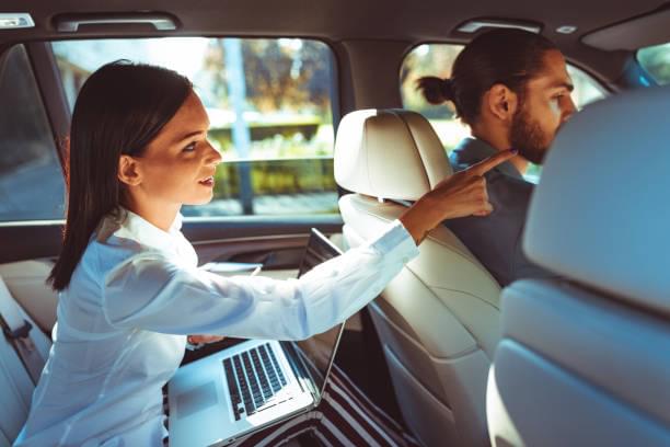 Chauffeur driven limousine with the business woman in the back seat